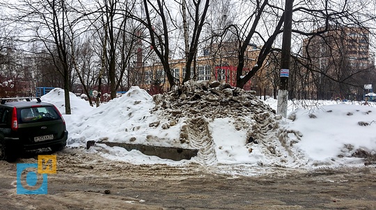 Во дворе дома на улице Чикина, 9, Кучи не убранного снега в Одинцово